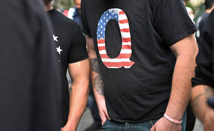 Un homme porte un t-shirt faisant référence au mouvement complotiste QAnon, à New York