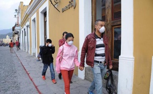 Des habitants d'Antigua Guatemala, au sud-ouest de Guatemala City, portent des masques pour ne pas respirer les cendres du volcan Fuego en éruption, le 7 février 2015