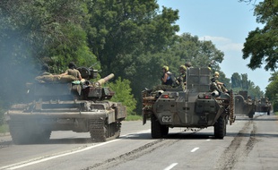 Une colonne de chars de l'armée ukrainienne traverse la ville de Druzhkivka, au nord de Donetsk. L'armée russe amasserait aussi ses forces dans cette zone à la frontière russo-ukrainienne.