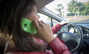 Une jeune femme au volant qui téléphone à Bordeaux.