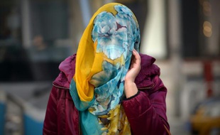 Une femme se protège le visage avec un foulard, à Pékin le 7 décembre 2015
