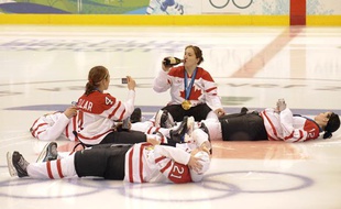 Les fille de l'équipe de Hockey du Canada, championnes olympiques fêtent leur victoire au champagne, sur la glace, le 25 février 2010.