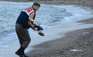 Un policier turc transporte le corps d'un enfant échoué sur une plage de Bodrum en Turquie, après le naufrage d'un bateau transportant des migrants, le 2 septembre 2015