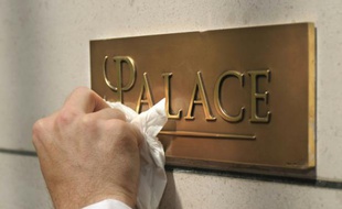 Un employé de l'hôtel Bristol nettoie la plaque "Palace", le 5 mai 2011 à Paris