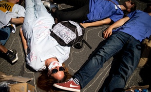 Du personnel soignant défile dans la rue, ils procèdent a un die-in, ils s'allongent par terre pour symboliser la mort de plusieurs patients et soignants a cause de la surcharge de travail et au manque d'effectif lors de la manifestation du personnel de sante en direction du ministère de la sante, en juin 2019.