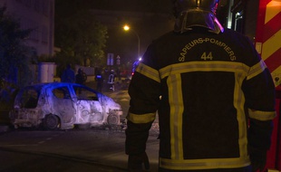 Un policier intervient sur des incendies de voitures à Nantes dans la nuit du jeudi 5 juillet au vendredi 6 juillet 2018.