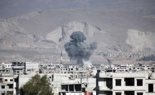 De la fumée s'élève d'un immeuble après un raid aérien des forces gouvernementales dans la ville d'Arbin en Syrie, le 17 février 2016