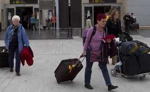 Des touristes trainent leurs valises à leur arrivée à l'aéroport de Tenerife, aux Canaries, le 9 février 2011.
