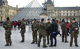 Des militaires en armes devant la pyramide du musée du Louvre à Paris, le 16 novembre 2015