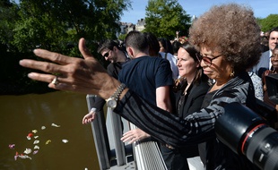 Angela Davis, ici a côté de Johanna Rolland, lance des fleurs dans la Loire dimanche après-midi. AFP / JEAN-SEBASTIEN EVRARD