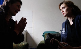 Angelina Jolie (D), ambassadrice de bonne volonté pour le Haut Commissariat des Nations unies pour les réfugiés rencontre une réfugiée bosniaque à Gorazde, le 5 avril 2010.