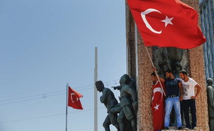Des opposants au putsch agitent un drapeau turc sur la place Taksim à Istanbul.