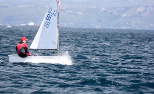 Un enfant sur un petit bateau à voile (illustration).