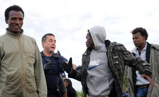 Un policier tente de stopper des migrants le 3 août 2015 à Coquelles près de Calais