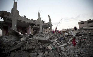 Des enfants palestiniens marchent dans les décombres d'immeubles de Gaza détruits pendant les 50 jours de guerre avec Israël, le 12 octobre 2014