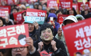 Un manifestant porte un masque à l'image de Park Geun-hye, lors d'une manifestation réclamant son arrestation le 27 mars 2017.