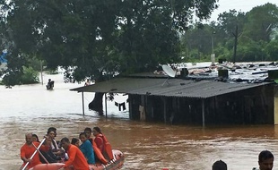 In this handout photograph taken and released by the National Disaster Response Force (NDRF) on July 27, 2019 NDRF personnel rescue passengers of the Mahalaxmi Express train stranded in a flooded area in-between Badlapur and Vangani following heavy monsoon rains, some 70 kms from Mumbai. - Indian navy helicopters and emergency service boats came to the rescue of about 700 people stuck on a train caught in floods near Mumbai on July 27. The Mahalaxmi Express left Mumbai late Friday for Kolhapur but got only 60 kilometres (37 miles) before it became stranded as torrential rain flooded the tracks. (Photo by Handout / Indian National Defence Response Force (NDRF) / AFP) / -----EDITORS NOTE --- RESTRICTED TO EDITORIAL USE - MANDATORY CREDIT "AFP PHOTO / Indian National Defence Response Force " - NO MARKETING - NO ADVERTISING CAMPAIGNS - DISTRIBUTED AS A SERVICE TO CLIENTS