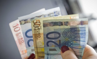 une personne compte ses billets de banque