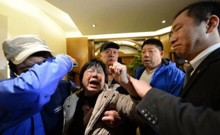 Des proches des passagers du vol MH370 pleurent à l'annonce des autorités malaisiennes, à Pékin le 24 mars 2014