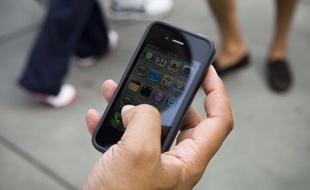 Un homme tient un iPhone 4 dans sa main le 24 juin 200 à New York.