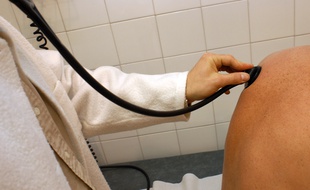 Un médecin généraliste consulte un patient dans son cabinet.
