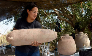 Une archéologue tient une des amphores de vin vieille de 1.500 ans découverte en Israël, sur le site de Yavné.