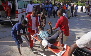 Des secouristes transportent un homme blessé dans un attentat à la voiture piégée, le 28 décembre 2019, à Mogadiscio, en Somalie.