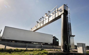 Un camion passe sous un portique écotaxe, endommagé par un incendie, en mars 2014 en Bretagne