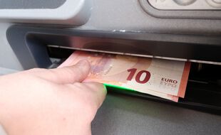 Illustration. Argent retiré dans un distributeur de monnaie