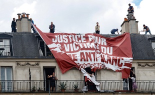 Des habitants d'un immeuble tentent de découper la banderole déployée par des militants d'extrême-droite, le samedi 13 juin 2020 à Paris.