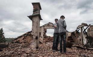 Des habitants dans les ruines de maisons détruites par les combats à Kumanovo, dans le nord de la Macédoine, le 11 mai 2015