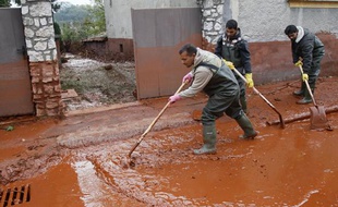 Des habitants nettoient leur village hongrois, mardi 5 octobre 2010, après qu'une coulée de boue rouge a envahi les rues.