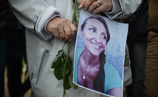 Dans une marche en hommage à Julie Douib à Vaires-sur-Marne, une femme tient un portrait de la jeune femme tuée par son ex-compagnon le 3 mars 2019.