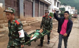 Rescuers carry an injuried child on a stretcher after a 6.1 magnitude earthquake hit the area in Ludian county in Zhaotong, southwest China's Yunnan province on August 3, 2014. The quake struck 11 kilometres (seven miles) west-northwest of the town of Wenping at a relatively shallow depth of 10 kilometres at 4:30 pm (0830 GMT). CHINA OUT AFP PHOTO