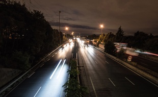 Une autoroute la nuit avec de la circulation automobile. (Illustration)