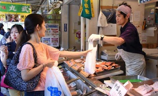 Une Japonaise achète du poisson à Tokyo le 1er mai 2015. L'inflation s'est légèrement redressée en mars au Japon