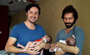 Un couple d'homosexuels espagnols José Antonio Fernandez (g) et Luis Delgado posent avec leurs bébés à Cancun au Mexique, le 18 février 2015