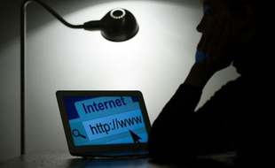 Une femme devant son ordinateur, se connecte à internet, le 15 mars 2013 à Paris