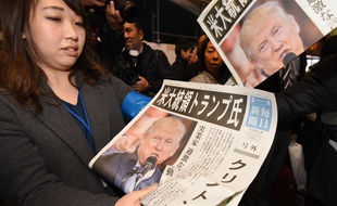 Une Japonaise distribue des éditions spéciales des journaux annonçant l'élection de Donald Trump, à Tokyo le 9 novembre 2016.