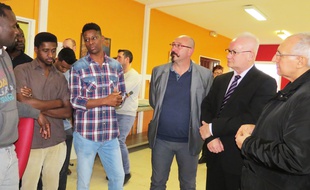 Le préfet du Pas-de-Calais, Fabien Sudry, (à droite), en grande discussion avec des migrants venus du Soudan et l'interprète, lors d'une visite le 20 décembre 2017, au centre d'accueil de Croisilles, près d'Arras.