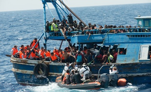 Illustration - Un bateau de migrants en train d'être secourus dans la mer Méditerranée.