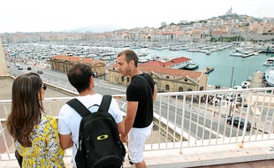 Max, Marseillais bénévole, fait découvrir avec enthousiasme sa ville à un couple de Brésiliens.