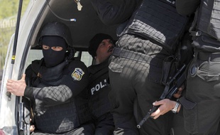 Des policiers tunisienscagoulé dans un véhicule, le 18 mars 2015