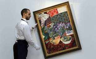 Un employé de Sotheby's accroche un tableau de Nathalie Gontcharoff à Londres, en 2012.
