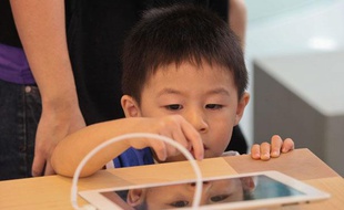 Un enfant joue avec un iPad dans un Apple Store (illustration).