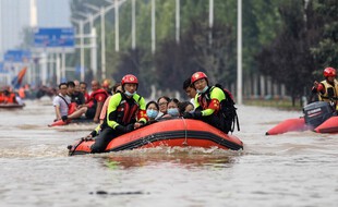 Des sauveteurs du service d'incendie et de secours de la ville de Yangzhou, dans l'est de la Chine, évacuent des personnes d'un hôpital à la suite de fortes pluies à Zhengzhou, dans la province chinoise du Henan, le 22 juillet dernier.