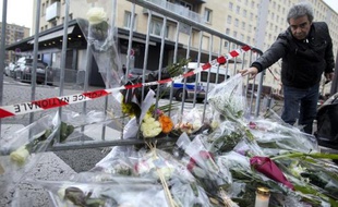 Un homme dépose des fleurs devant l'épicerie juive porte de Vincennes, au lendemain de la prise d'otages par Amedy Coulibaly qui a fait 4 morts