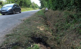 Une voiture passe sur le lieu d'un accident qui a coûté la vie à quatre mineurs à Rohan, dans l'ouest de la France, dans la nuit du 1er au 2 août 2015
