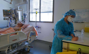Un soignant avec un patient infecté par le Covid-19 dans une chambre de l'hôpital CHU Pasteur de Nice
