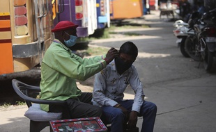 Un homme nettoyant l'oreille d'un autre en Inde, le 11 septembre 2020.